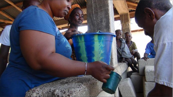 At a community gathering in Tilorma village, Kenema district, Sierra Leone, hand-washing became routine after the outbreak of Ebola. The virus has killed nearly 4,000 people in Sierra Leone. ~umcom photo/Jan Snider