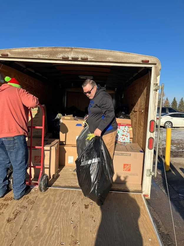 Men unloading boxes from a trailer