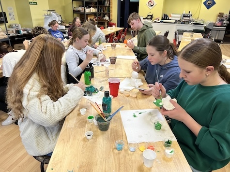 Youth sitting at table painting