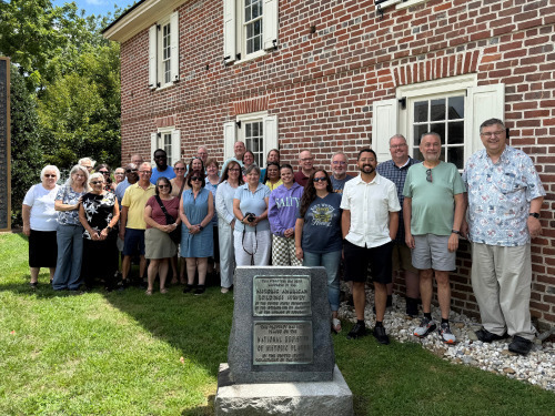Group posing outside brick building