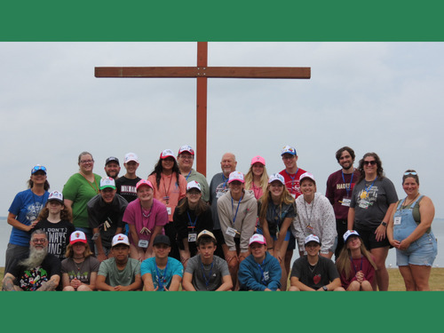Youth with cross at lakeside